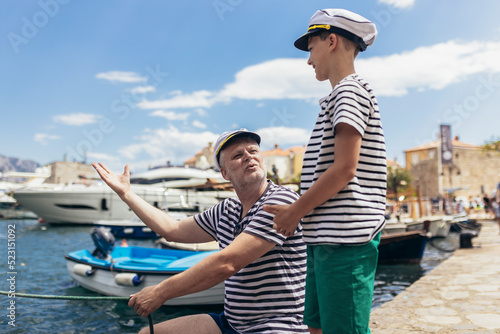 Father and son spending time at marina on summer day.