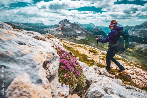 Young woman is hiking on beautiful trail Seekofel to Baires Lake in the Dolomite mountains in the afternoon. Seekofel , Dolomites, South Tirol, Italy, Europe. photo
