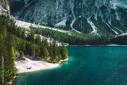 Fototapeta Naklejka Na Ścianę i Meble -  Beautiful view people staying at the shore of turquoise Baires Lake in the Dolomite mountains in the afternoon. Braies Lake (Pragser Wildsee, Lago di Braies), Dolomites, South Tirol, Italy, Europe.