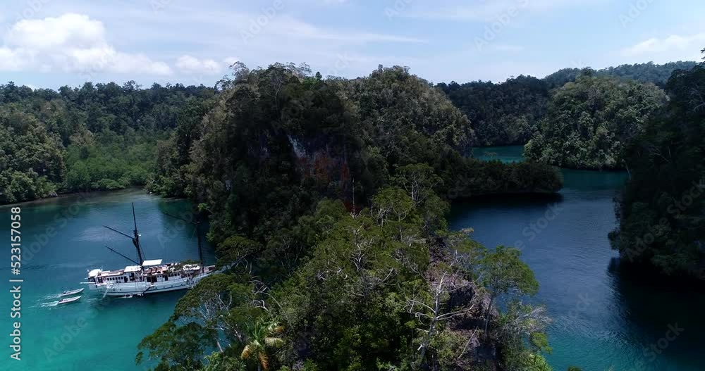 Aerial shot of diving boat navigating between rocky islands