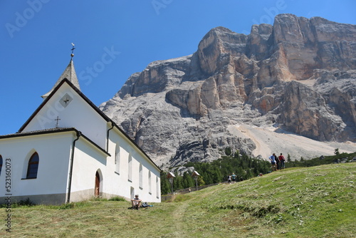 Val Badia, Italy-July 17, 2022: The italian Dolomites behind the small village of Corvara in summer days with beaitiful blue sky in the background. Green nature in the middle of the rocks. photo