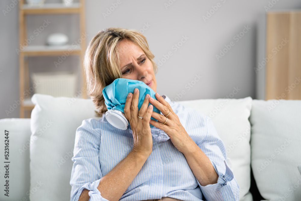 Upset Young Woman Touching Cheek With Cold Water Bag Upset Young Woman Touching Cheek With Cold Water Bag