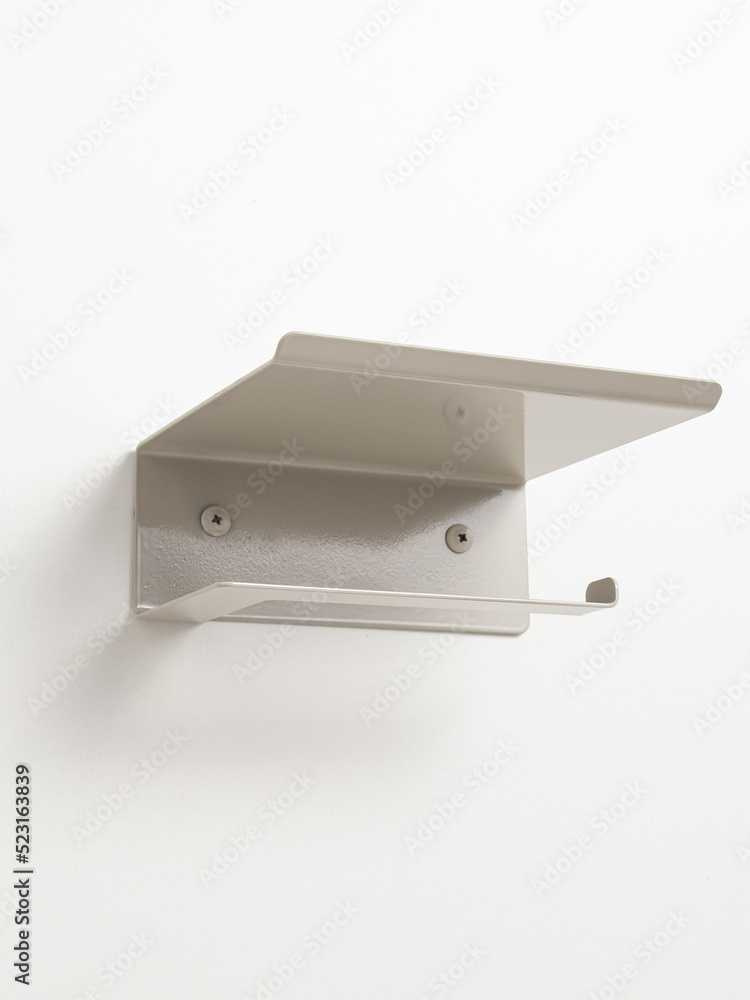 Empty beige steel toilet paper holder on white background. Storage in the toilet room Empty beige steel toilet paper holder on white background. Storage in the toilet room