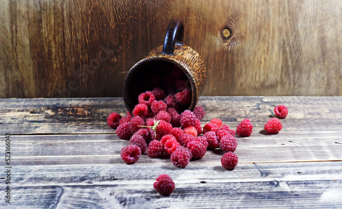 Raspberries in a wooden glass on a wooden background