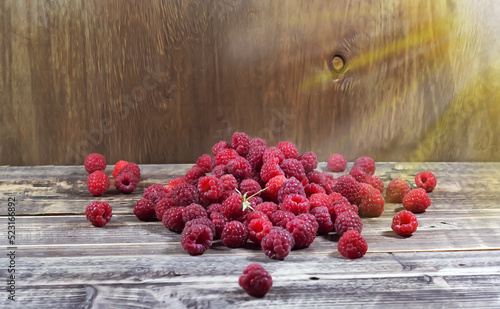 Raspberries in a wooden glass on a wooden background