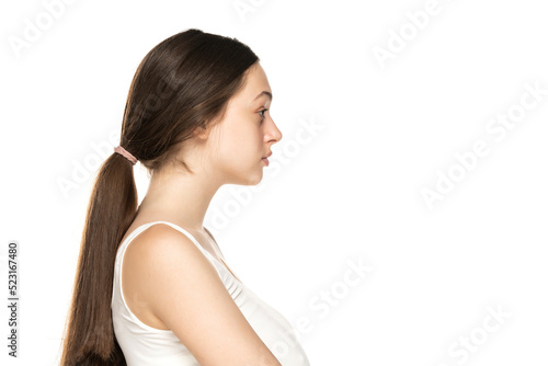 Profile view of a beautiful young women without makeup on white background.