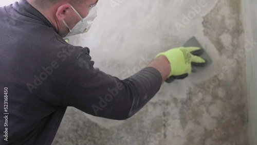 Removal of fungus and mold at home, peeling the first layer of fungus on the wall with a spatula.