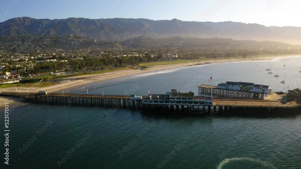 Aerial Forward Beautiful Shot Of Jetty In Sea At Beach By City - Santa Barbara, California Aerial Forward Beautiful Shot Of Jetty In Sea At Beach By City - Santa Barbara, California