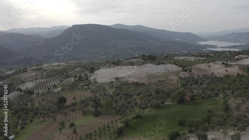 Aerial Drone view of Green Fields, Hills and Trees in a with Small Houses. Turkey.