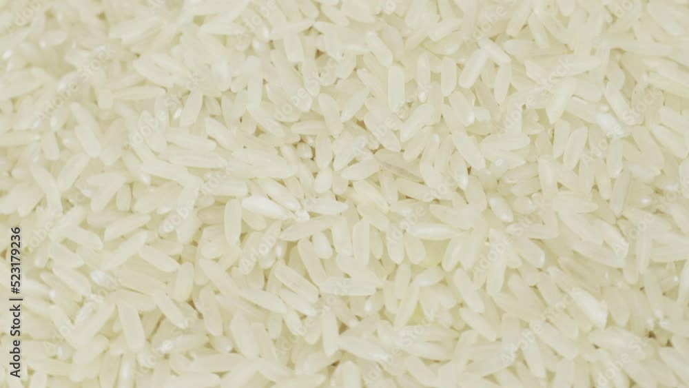Raw grains of rice, rotating background - top view. Close-up. Raw grains of rice, rotating background - top view. Close-up.
