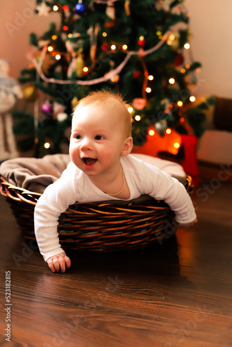a baby under the tree. the family celebrates Christmas.
