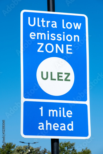 Close up of ULTRA LOW EMISSION ZONE sign against a clear blue sky. photo