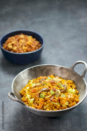 Fried rice with scramble egg and meatball, cabbage vegetables such as spring onion, shredded chicken. Grey background. Front view, copy space,