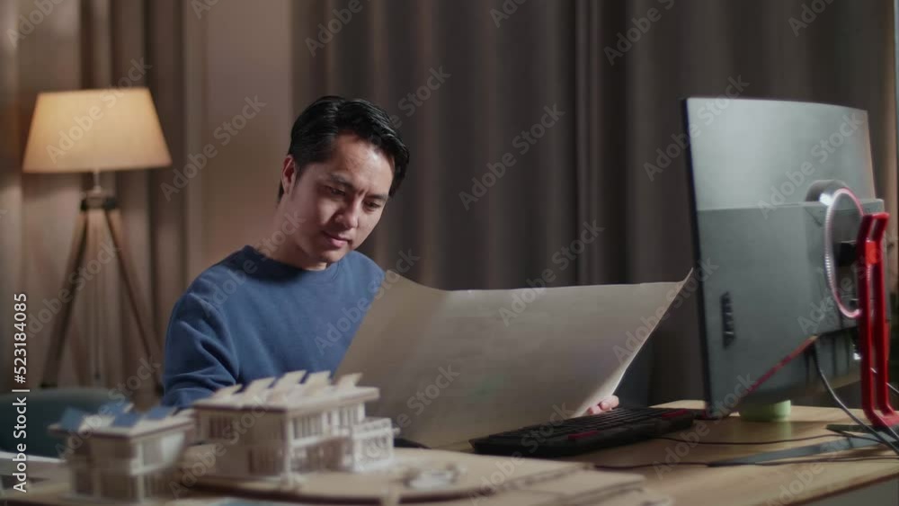 Asian Male Engineer With The House Model Opening And Looking At The Blueprint While Working On A Desktop At Home
Asian Male Engineer With The House Model Opening And Looking At The Blueprint While Working On A Desktop At Home