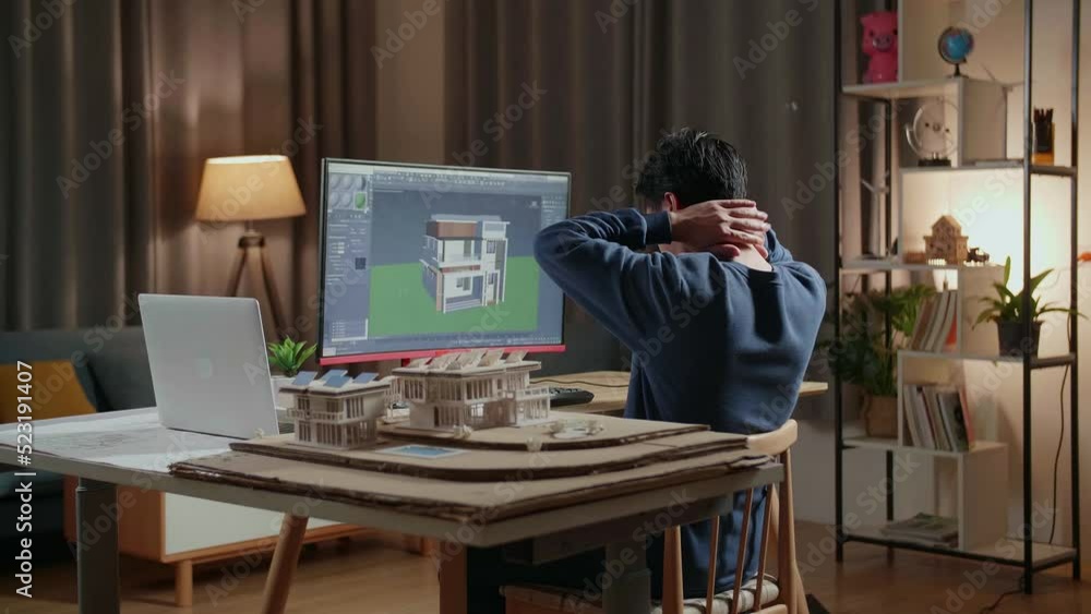 Asian Male Engineer Stretching While Designing House On A Desktop At ...