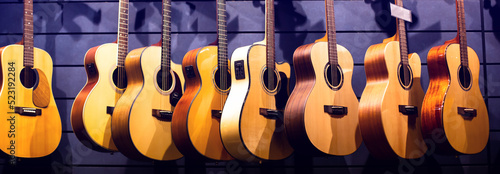 Selective focus to guitar in music shop, many guitars, pop rock artist song music and entertainment instrument.