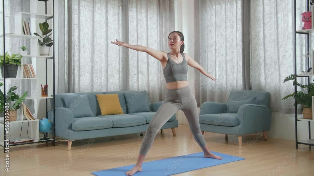 Young Asian Athletic Female Exercising, Stretching And Practicing Yoga In Warrior Ii Pose At Home. Healthy Lifestyle, Fitness, Wellbeing And Mindfulness Concept
Young Asian Athletic Female Exercising, Stretching And Practicing Yoga In Warrior Ii Pose At Home. Healthy Lifestyle, Fitness, Wellbeing And Mindfulness Concept
