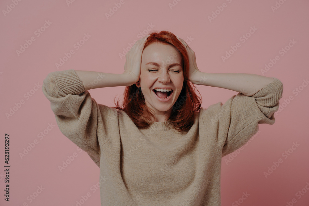 Excited caucasian red-haired woman reacting positively on good news isolated over pink background Excited caucasian red-haired woman reacting positively on good news isolated over pink background