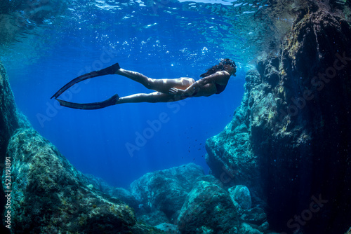 a girl swims underwater in apnea in the Mediterranean Sea 