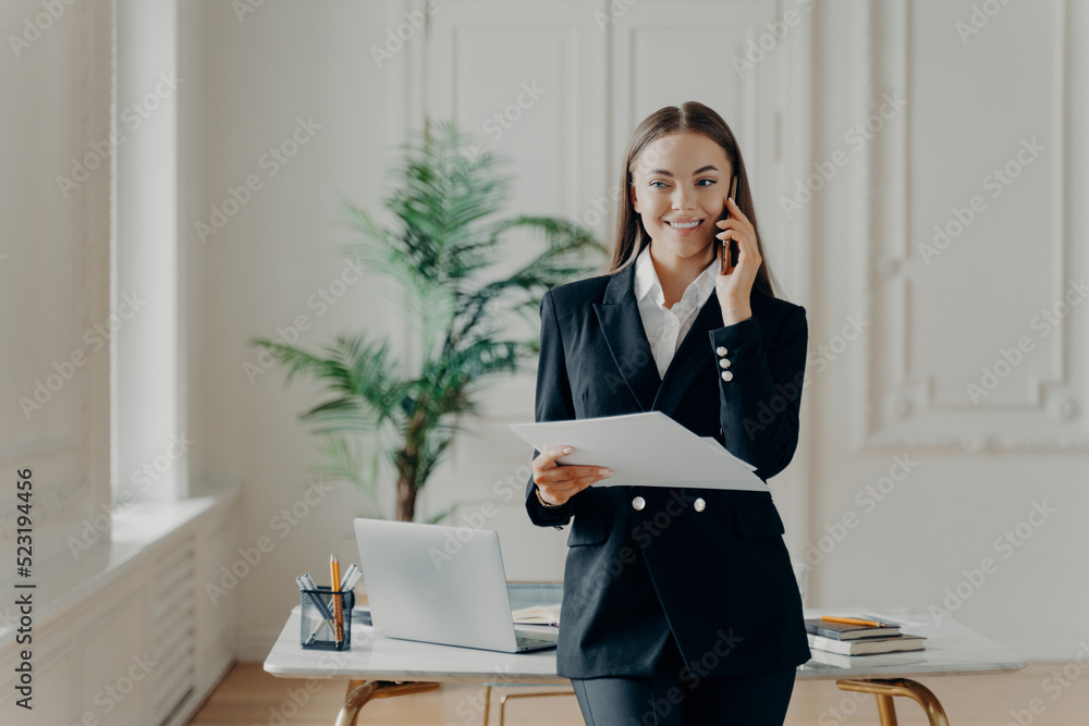 Happy businesswoman talking on phone and enjoying conversation Happy businesswoman talking on phone and enjoying conversation