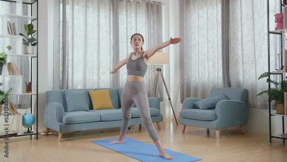 Young Asian Athletic Female Exercising, Stretching And Practising Yoga In Warrior Ii Pose At Home. Healthy Lifestyle, Fitness, Wellbeing And Mindfulness Concept
Young Asian Athletic Female Exercising, Stretching And Practising Yoga In Warrior Ii Pose At Home. Healthy Lifestyle, Fitness, Wellbeing And Mindfulness Concept
