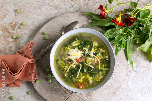 Foto plate of minestrone soup with spinach and broccoli on a light table