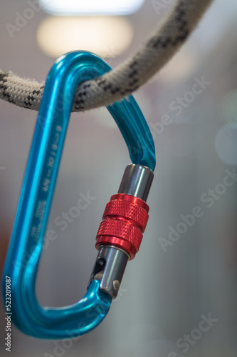 Versatile, lightweight aluminum screw-locking carabiner hanging on a rope for climbing