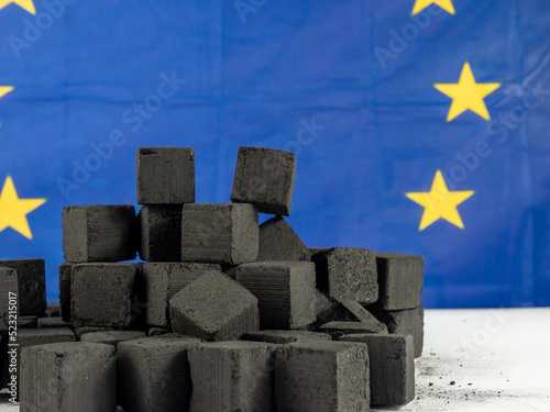 Black cubes of coal on the background of the EU flag. Concept Coal shortage in Europe.