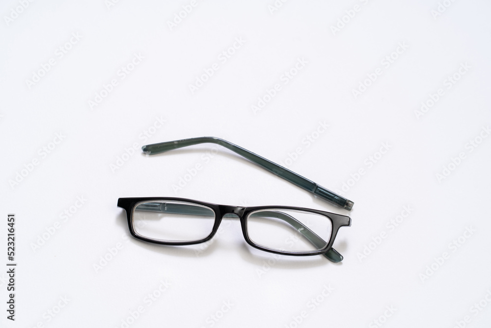 Broken reading glasses on white background Broken reading glasses on white background