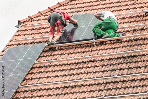Wallpaper Mural Man installing new solar panels on the roof of a private house. Renewable energy concept. Iinstallation of photovoltaics. Energy saving. Torontodigital.ca