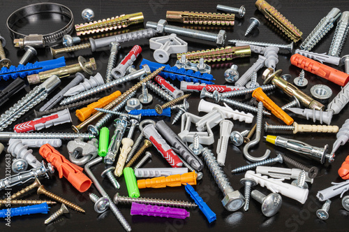 Different types of fasteners on a dark wood background.