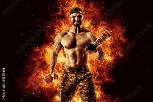 Bodybuilding concept. Brutal strong muscular bodybuilder athletic man pumping up muscles with barbell on black background with fire