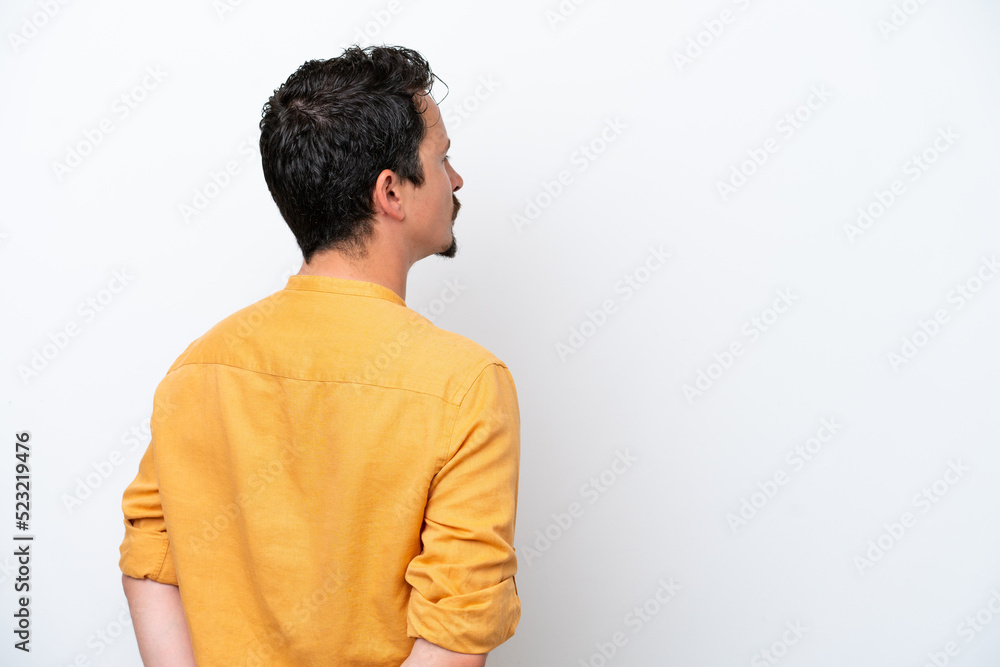 Young man with moustache isolated on white background in back position and looking back Young man with moustache isolated on white background in back position and looking back