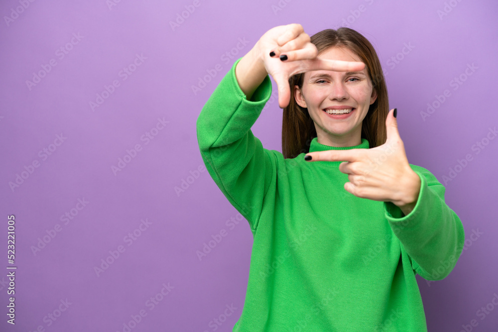 Young English woman isolated on purple background focusing face. Framing symbol Young English woman isolated on purple background focusing face. Framing symbol