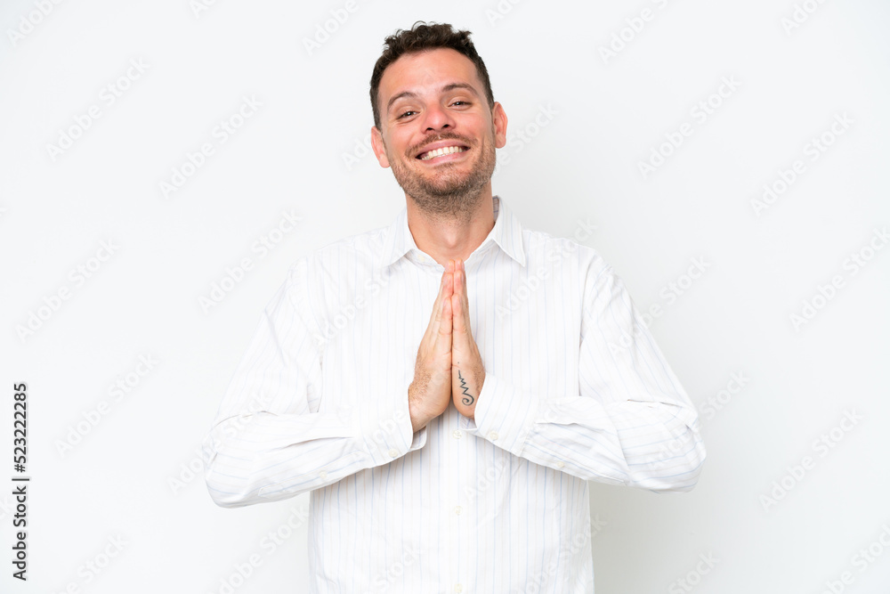 Young caucasian handsome man isolated on white background keeps palm together. Person asks for something Young caucasian handsome man isolated on white background keeps palm together. Person asks for something