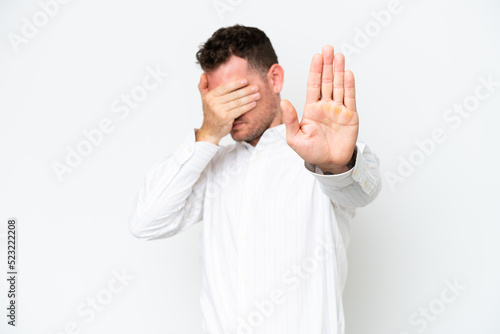 Young caucasian handsome man isolated on white background making stop gesture and covering face