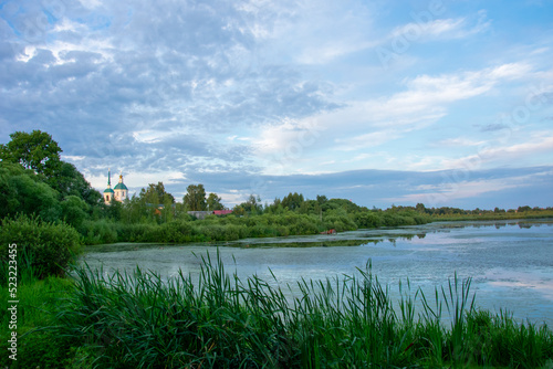 Canvas Print duckweed covered lake kiovo, moscow region, russia, Orthodox church on the shore