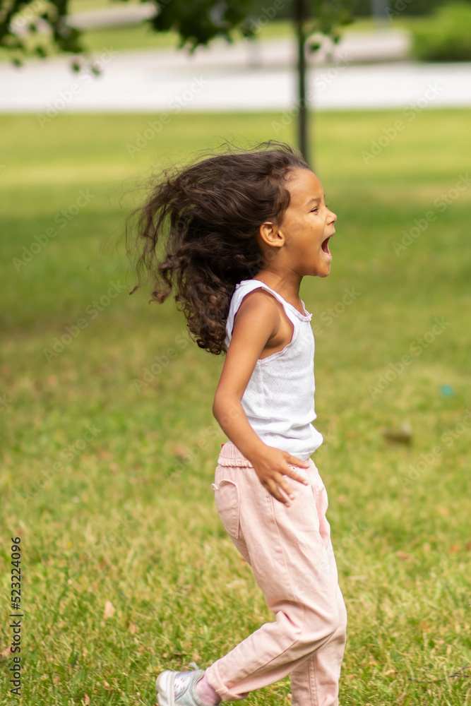happy african american child outdoor, a girl in the park has fun, the child runs and screams, plays,happy childhood happy african american child outdoor, a girl in the park has fun, the child runs and screams, plays,happy childhood