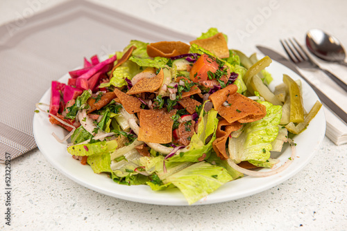 Healthy fattoush salad closeup. The key ingredient in this middle eastern dish is the toasted pita bread which is mixed with healthy vegetables, herbs and a dressing made with lemon and sumac.