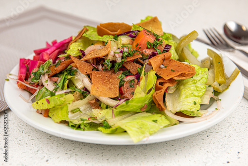 Healthy fattoush salad closeup. The key ingredient in this middle eastern dish is the toasted pita bread which is mixed with healthy vegetables, herbs and a dressing made with lemon and sumac.