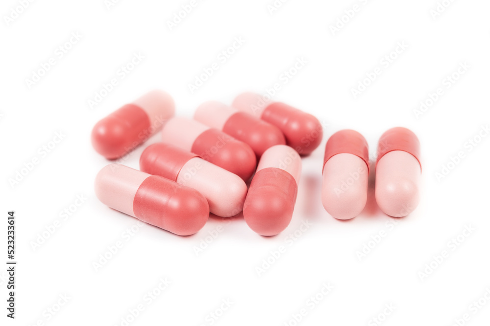 Isolated gel capsules. Multiple pink softgel capsules randomly placed. Used to administer drugs, medicine, supplements or oil for people or pets. Selective focus. White background. Isolated gel capsules. Multiple pink softgel capsules randomly placed. Used to administer drugs, medicine, supplements or oil for people or pets. Selective focus. White background.
