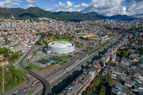Obraz na płótnie Carrera 30 de la ciudad de Bogotá ( Colombia), donde se puede visualizar el movistar arena y el estadio el campin y el lago del parque de los novios en primer plano y al fondo el centro de la ciudad. w salonie