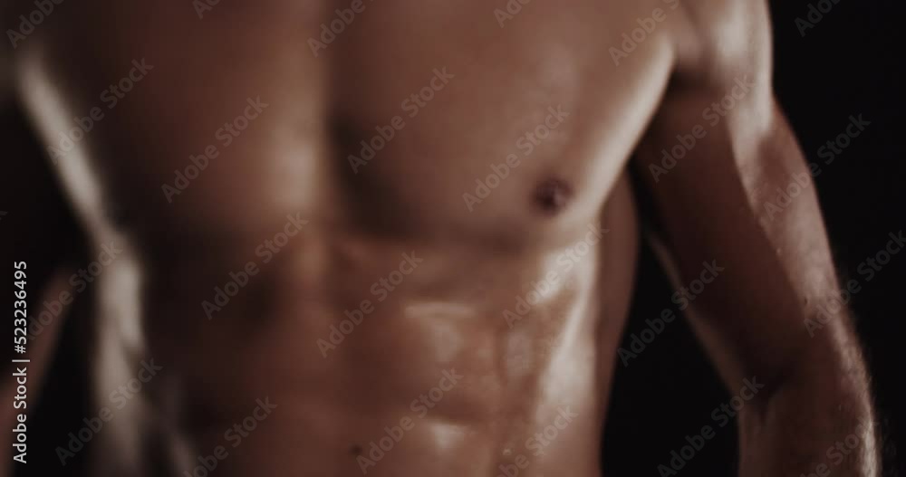 Playing with his muscles while being topless, selective focus Playing with his muscles while being topless, selective focus