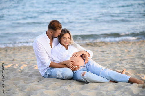 Pregnancy Happiness.Cute Family Moments, Parents-To-Be. Side View, Copy Space. Happy pregnancy woman and husband hugging pregnant belly.  Concept of pregnancy, maternity, expectation for baby birth.