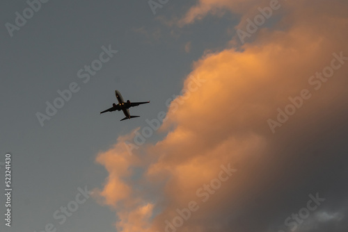 Silhouette of an airplane on sunset background.