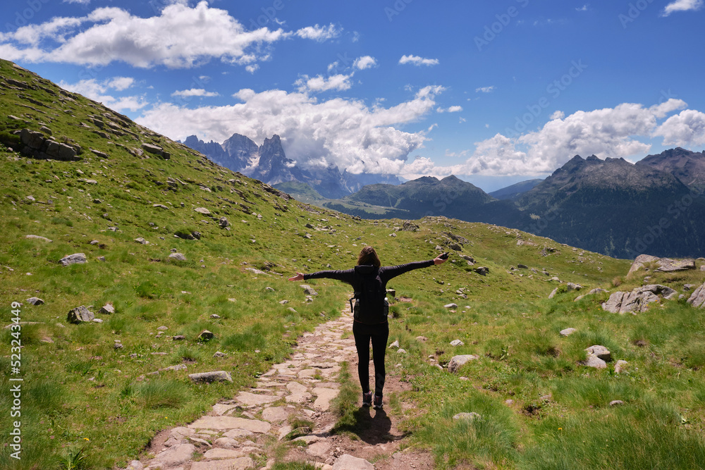 woman with open arms on the trails of the Trentino Dolomites