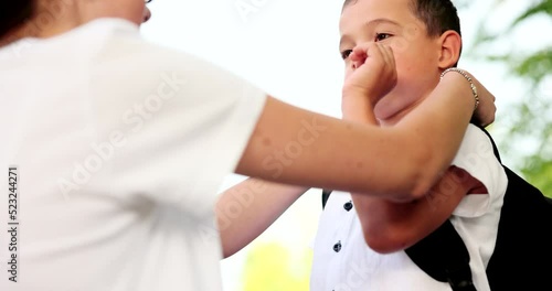 First day of school. A loving mother drops her son off at school for his first day in lockdown after fixing his shirt