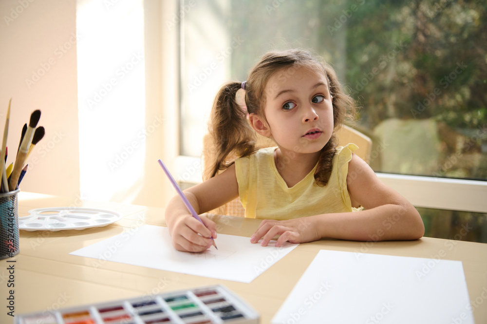 Purposeful, talented and creative Caucasian child ,a little schoolgirl painting an image with watercolors on a summer terrace. Art class. Development and entertainment for children. Creativity and art Purposeful, talented and creative Caucasian child ,a little schoolgirl painting an image with watercolors on a summer terrace. Art class. Development and entertainment for children. Creativity and art