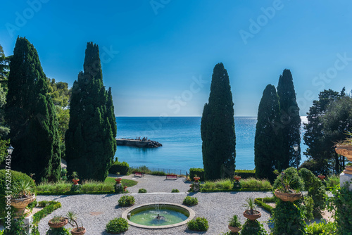 park of the castle miramare in trieste, italy, with fontain, cypresses and vie to the sea