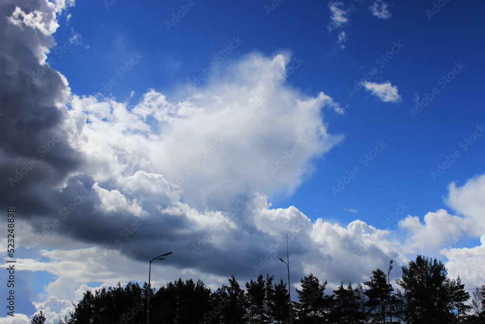 large white cloud and blurry white strokes against a bright blue sky. The cumulus nature of the clouds is a harbinger of a downpour large white cloud and blurry white strokes against a bright blue sky. The cumulus nature of the clouds is a harbinger of a downpour